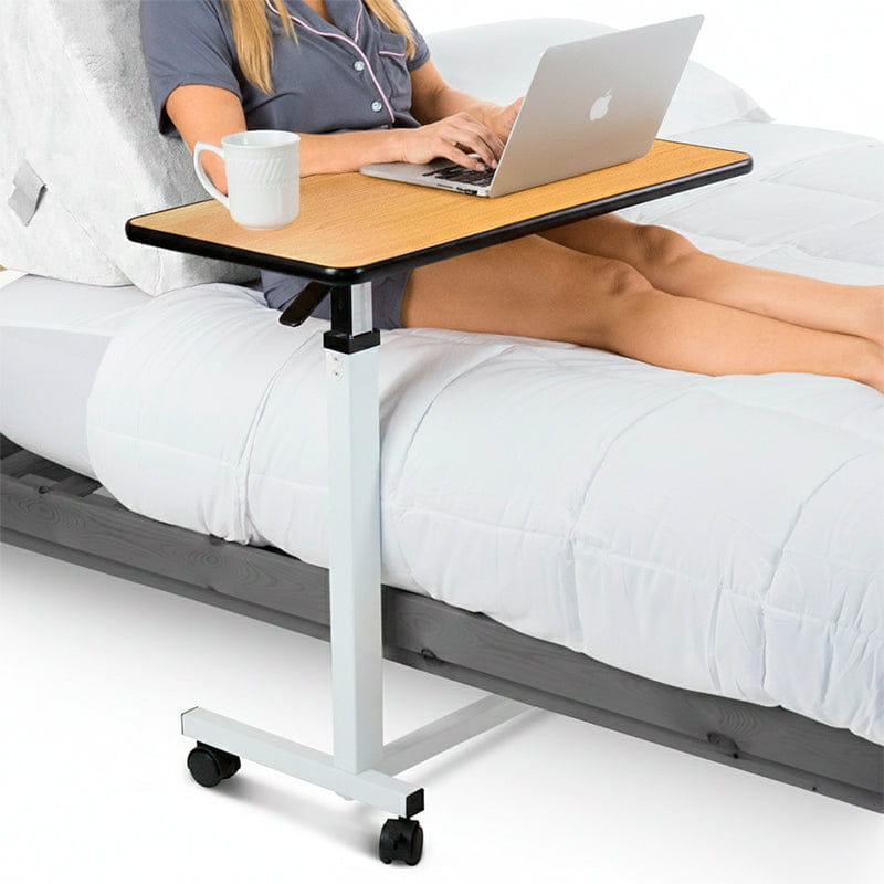 Vive wheeled overbed table shown in use beside a bed